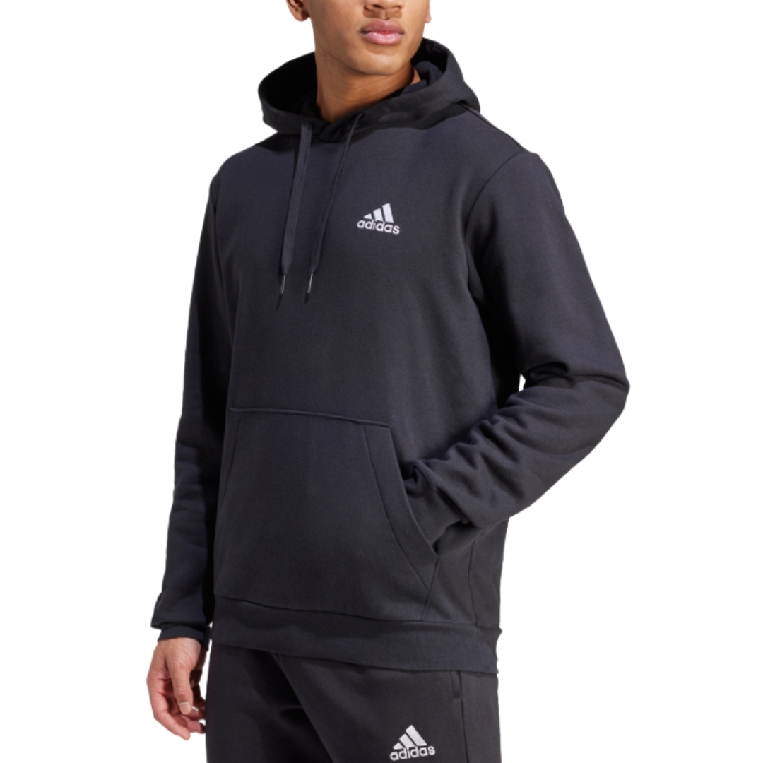 A black Adidas hoodie with a white logo on the chest, featuring a drawstring hood and a front pocket, paired with matching black Adidas pants.