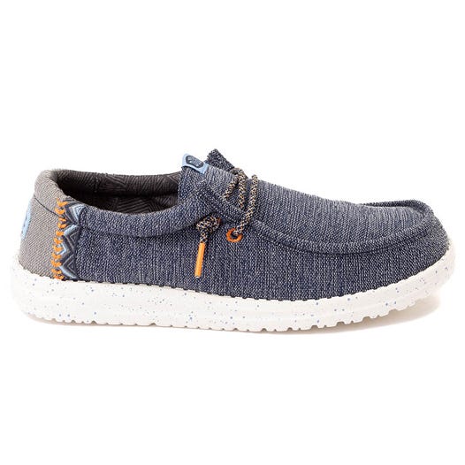 A casual slip-on shoe with a denim-like fabric, white speckled sole, and decorative laces. Ideal for relaxed, everyday wear.