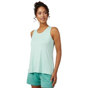 A woman is wearing a mint green sleeveless tank top made of a lightweight fabric suitable for sleep or casual wear, paired with matching green shorts.