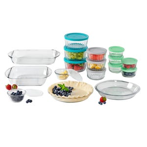 The 30pc Anchor Hocking Food Storage Set includes glass baking dishes, pie plates, and various glass storage containers with colorful lids. It features two rectangular dishes, two pie pans, and multiple small round containers, ideal for both baking and storage.