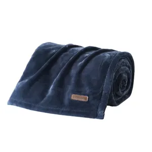 Rolled-up navy blue fleece blanket with a brown label.