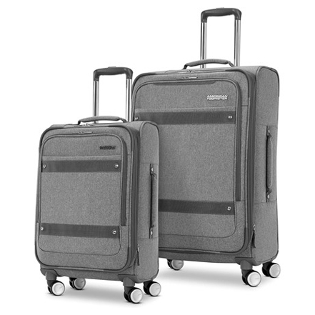 Two pieces of grey, wheeled luggage, one larger checked size and one smaller carry-on size.