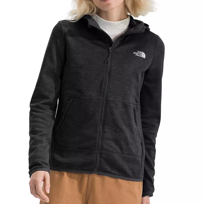 A person wearing a dark grey hoodie with a zipper and The North Face logo on the left chest, paired with brown pants.