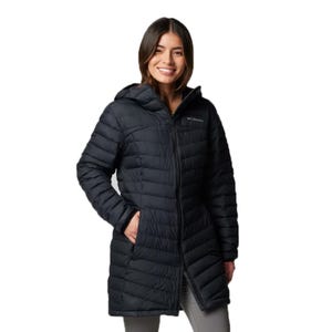 A woman is wearing a long-sleeve, black, quilted Columbia hooded jacket.