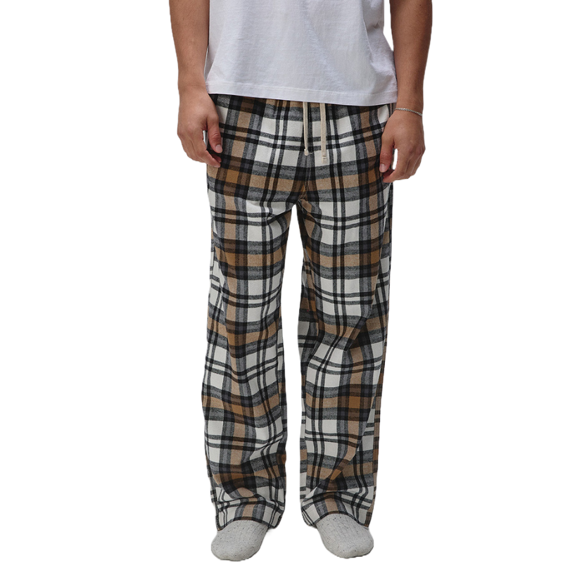 A person wearing plaid pajama pants in brown, black, and white, paired with a white shirt and gray socks.