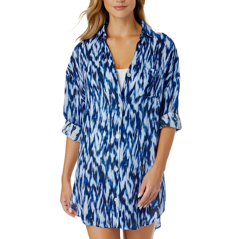 A woman's long-sleeve, blue and white patterned button-up shirt, worn over a white top.