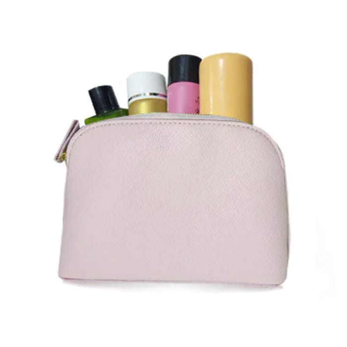 A pale pink cosmetic bag with various bottles peeking out from the top.
