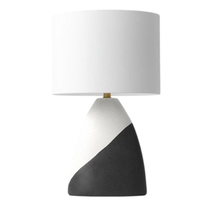 A modern table lamp with a white cylindrical shade and a two-toned base featuring white and dark gray angled sections.