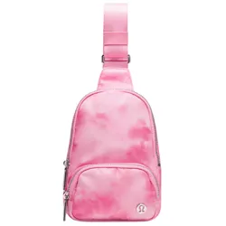 A small pink sling bag with a tie-dye pattern, featuring a front zippered pocket and an adjustable strap. The brand logo is visible on the front of the bag.