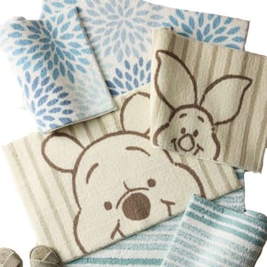 Towels featuring cartoon characters with striped and floral patterns in blue and cream tones are arranged together.
