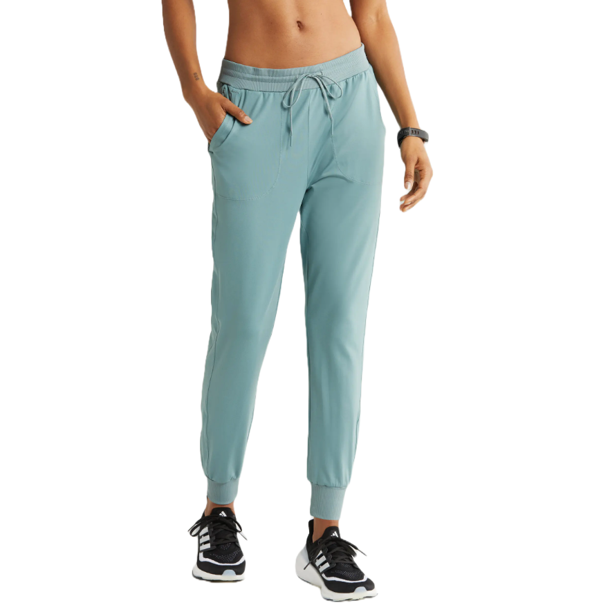 A person is wearing light blue joggers with a drawstring waist, ribbed ankle cuffs, and side pockets, paired with black and white sneakers.