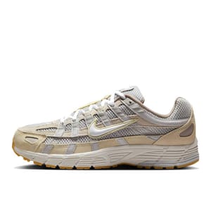 Nike P-6000 shoes feature a beige and light gray colorway with a mesh and synthetic upper, white midsole, and gum outsole. They are designed with a sporty, retro aesthetic.