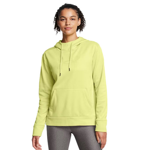 A woman wearing a light green hooded sweatshirt with long sleeves and a front pocket, paired with gray leggings.