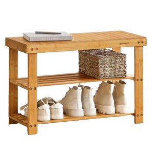 A bamboo 28\“ bench with two slatted shelves holds shoes and a woven basket, while the top features books.