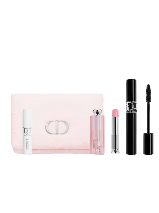 A cosmetic set includes a white serum bottle, pink lip balm, black mascara, and a light pink pouch with a metallic clasp.