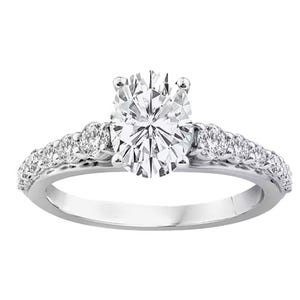 A diamond engagement ring featuring an oval-cut center stone in a prong setting with additional round diamonds embedded along the band.