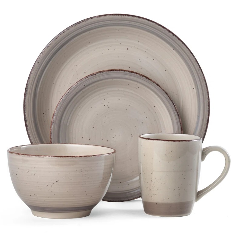 A four-piece stoneware dinnerware set featuring a bowl, mug, dinner plate, and salad plate, each with a textured beige finish and subtle speckled design.