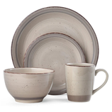 A four-piece stoneware dinnerware set featuring a bowl, mug, dinner plate, and salad plate, each with a textured beige finish and subtle speckled design.