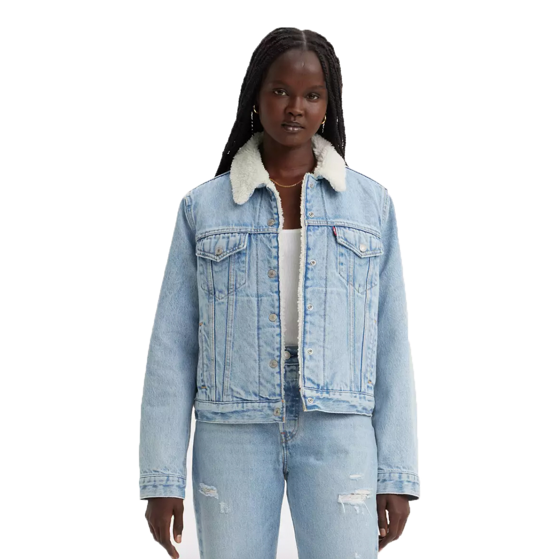 A woman wearing a light blue denim jacket with a faux shearling collar, paired with distressed light blue jeans.