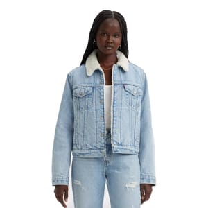 A woman wearing a light blue denim jacket with a faux shearling collar, paired with distressed light blue jeans.
