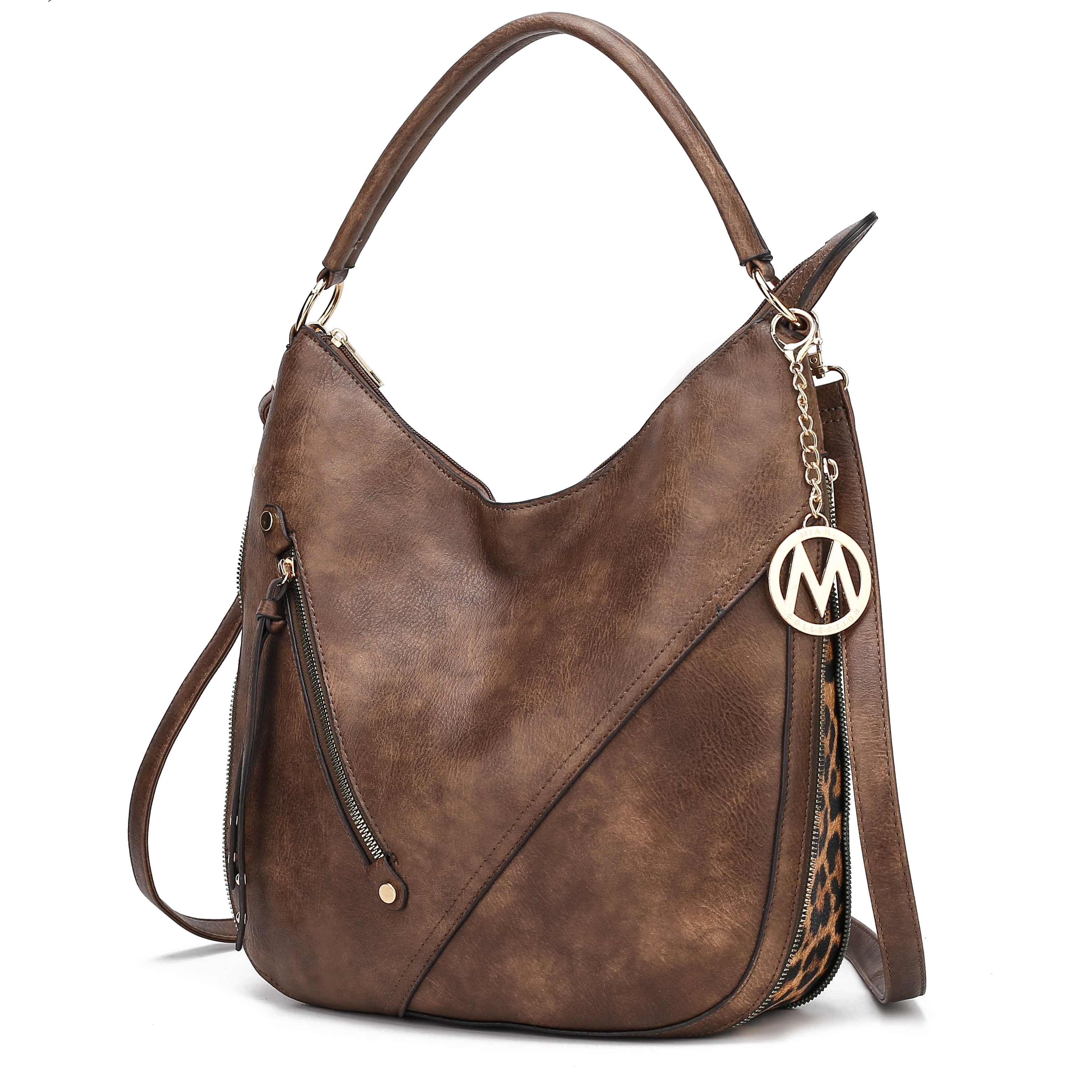A brown faux leather hobo bag with a decorative metal logo charm and a patterned strap detail.