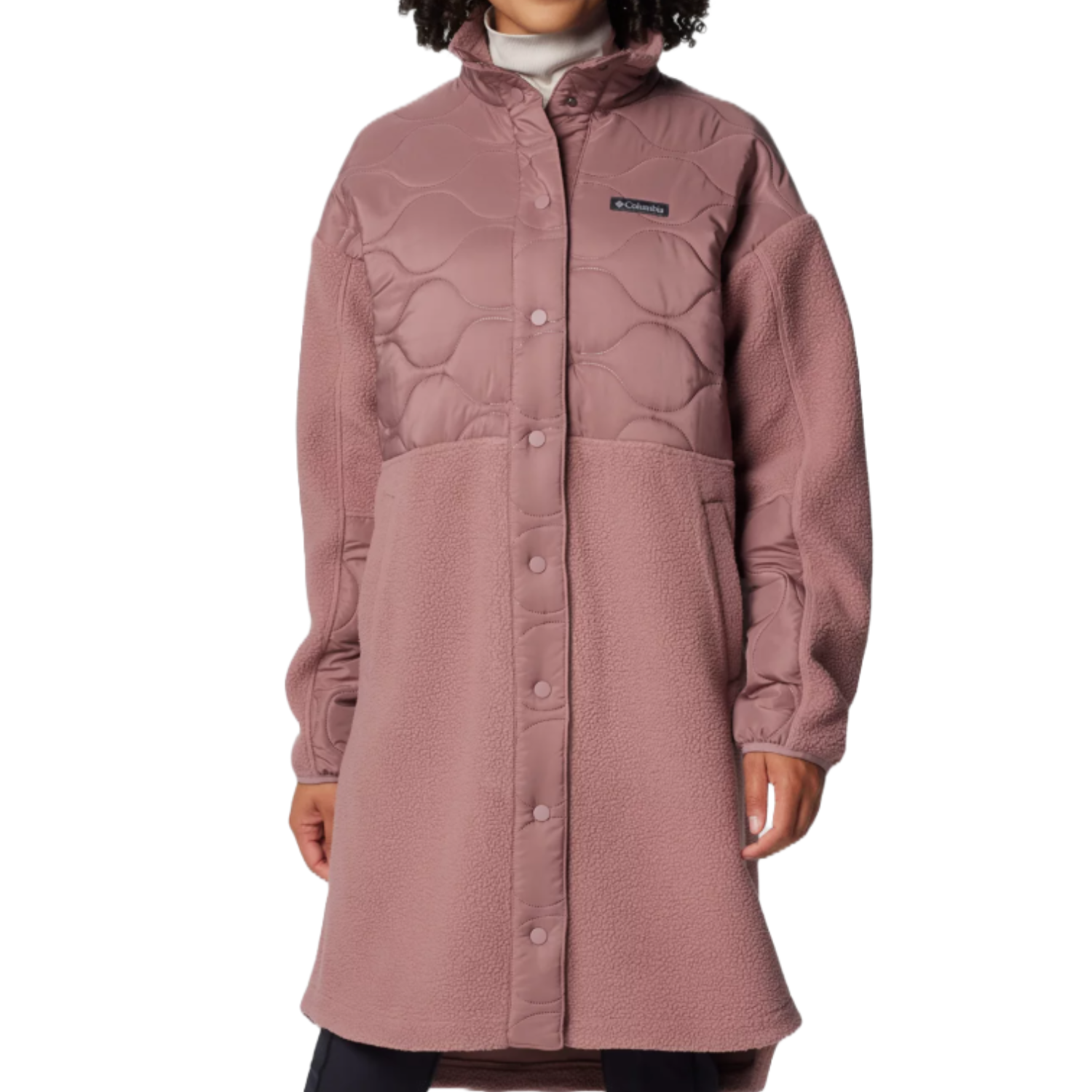 A long, rose-colored Columbia fleece jacket featuring a quilted top and button closure, with a high collar and pockets on the sides.