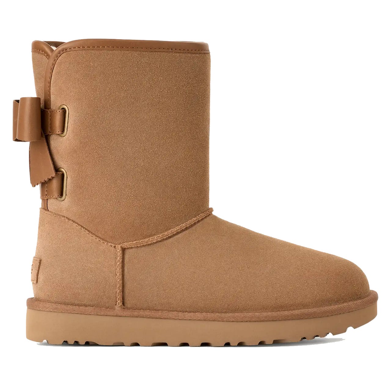 Tan suede boot with a side bow detail, featuring a flat sole and mid-calf height.