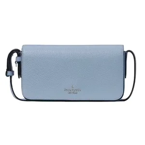 A light blue Kate Spade crossbody bag with a pebbled leather texture, featuring a compact design and a simple strap.