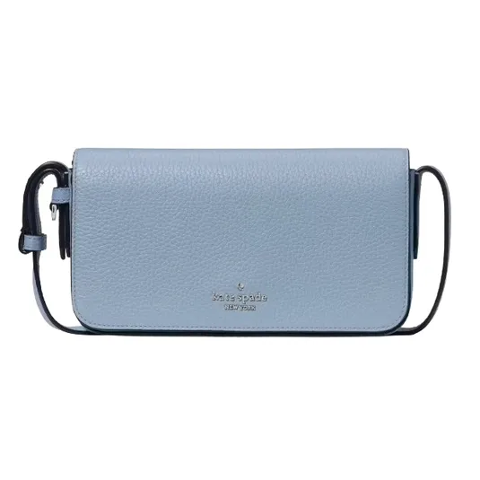 A light blue Kate Spade crossbody bag with a pebbled leather texture, featuring a compact design and a simple strap.