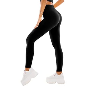 A person is wearing high-waisted black leggings and white platform sneakers.