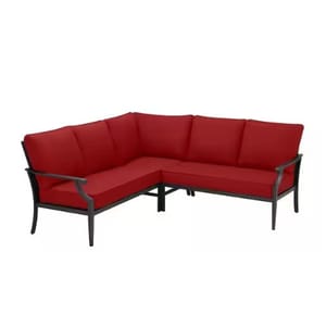 Red cushioned L-shaped outdoor sectional sofa with metal frame and armrests.