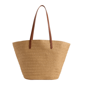 A woven straw tote bag with brown leather handles, featuring a spacious and open-topped design.