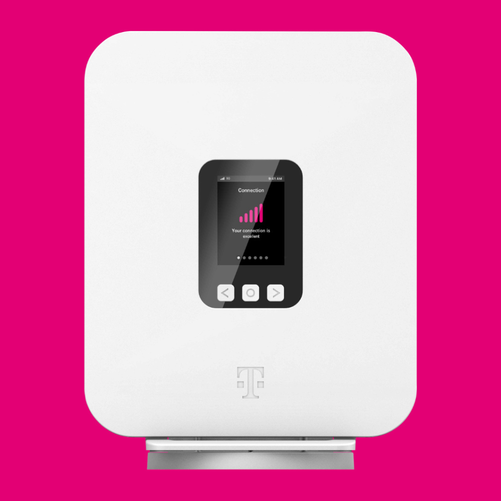 A white router with a digital display showing connection strength and navigation buttons, featuring a magenta background and a subtle logo below the screen.