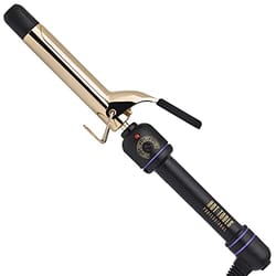 Gold-plated barrel curling iron with a black handle, a rotating temperature control dial, and a flipper to hold hair in place.