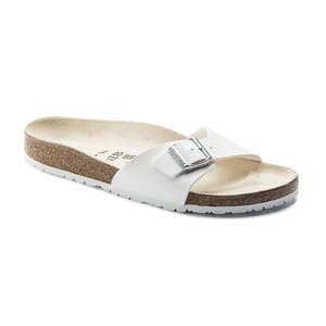 A white slide sandal with a cork footbed and a single adjustable buckle strap.