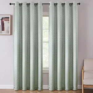 Light green curtains with a subtle geometric pattern hang on a black rod, partially covering a window. A small picture is on the wall, and a beige chair is visible to the right.