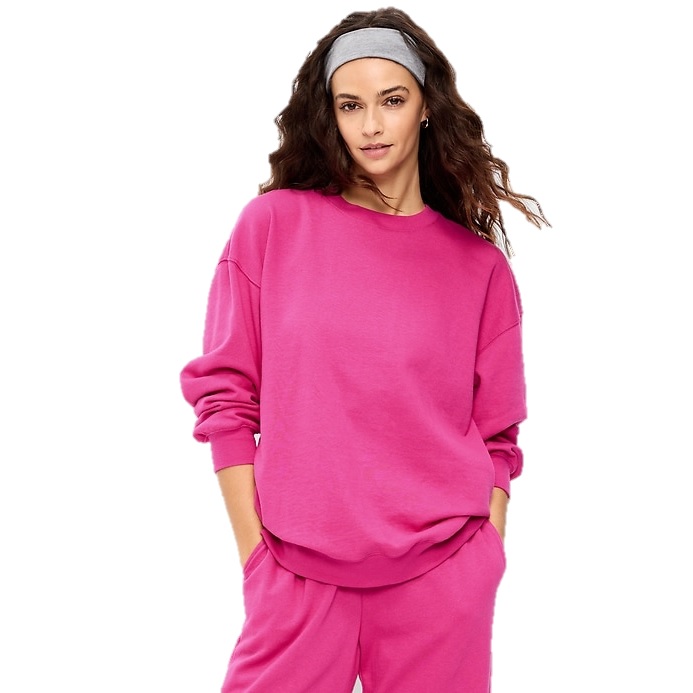 A person is wearing a bright pink sweatshirt and matching pants. They also have a gray headband in their hair.