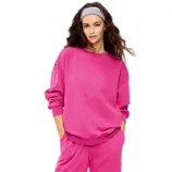 A person is wearing a bright pink sweatshirt and matching pants. They also have a gray headband in their hair.
