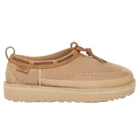 A tan suede moccasin-style shoe with stitching details, a thick sole, and lace closures at the top, featuring a loop on the back for easy wear.