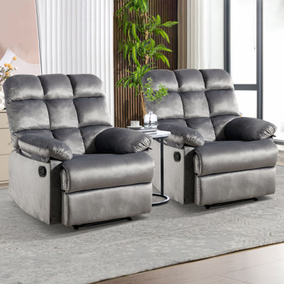 Two plush gray recliners with pillow-top armrests and built-in cup holders, set on a patterned rug in a well-lit room.