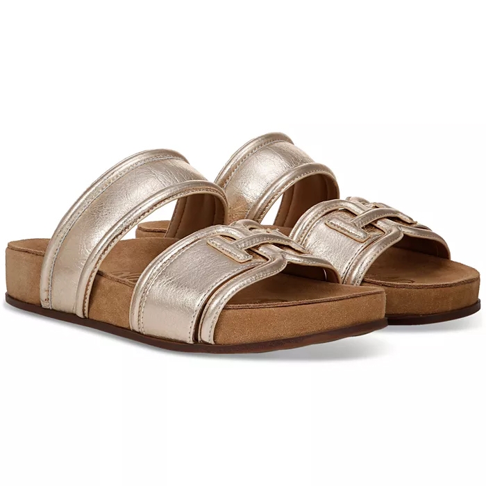 The Sam Edelman Rowan Emblem Footbed Sandals feature a metallic gold finish with two straps, an emblem design on the front strap, and a cushioned footbed for comfort. They have a slight platform sole with a casual, stylish look.