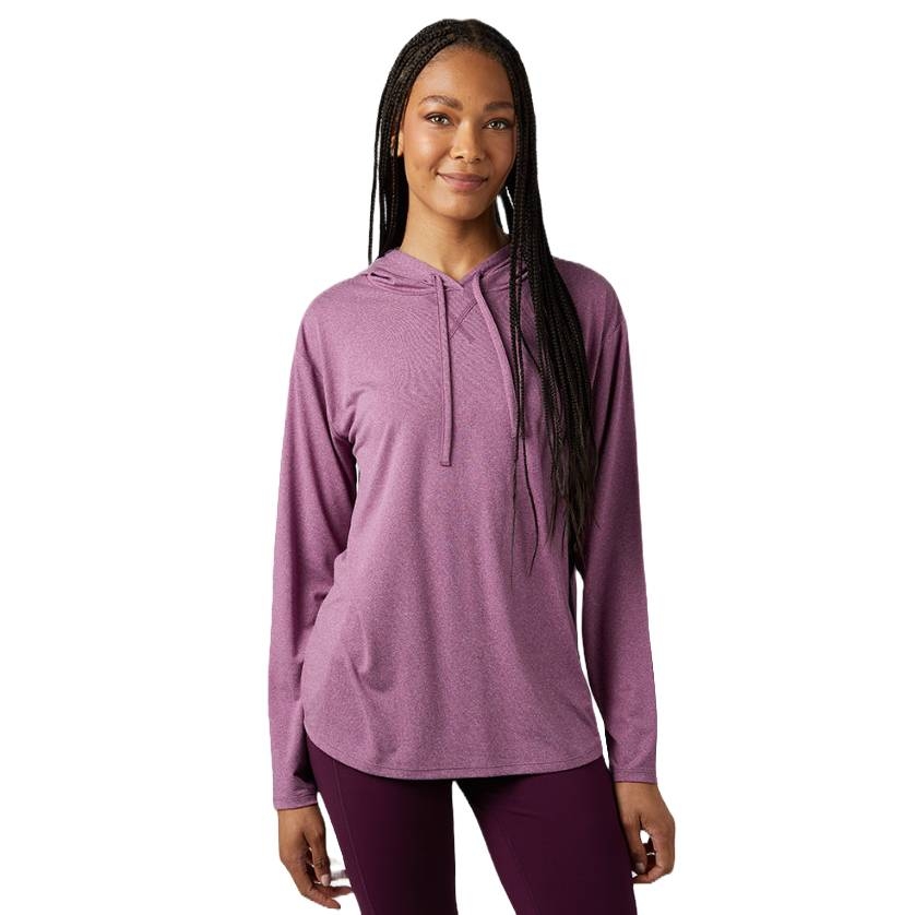 A woman is wearing a long-sleeve, light purple hooded top and dark purple leggings.