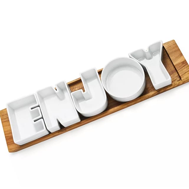 6pc Enjoy Food Serving Set features ceramic dishes shaped as letters spelling \“ENJOY,\“ placed on a rectangular wooden tray. Each letter acts as a small bowl for serving snacks or condiments.