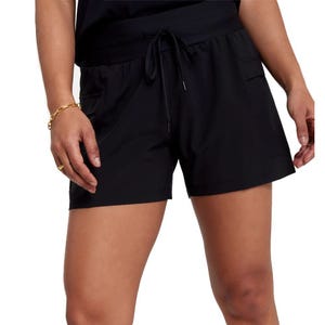 Person wearing black athletic shorts with an elastic waistband, drawstring, and side pockets.