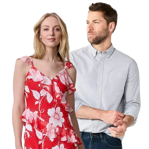 A woman in a red floral dress with ruffled straps stands next to a man in a light gray long-sleeve button-up shirt and jeans.