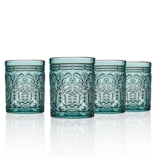 A set of four ornate, textured aqua-blue glass tumblers with intricate decorative patterns and a reflective base.