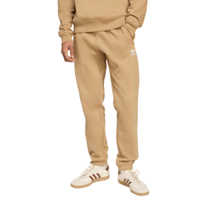 A person is wearing beige adidas sweatpants with the logo on the left thigh, paired with white sneakers featuring brown stripes.