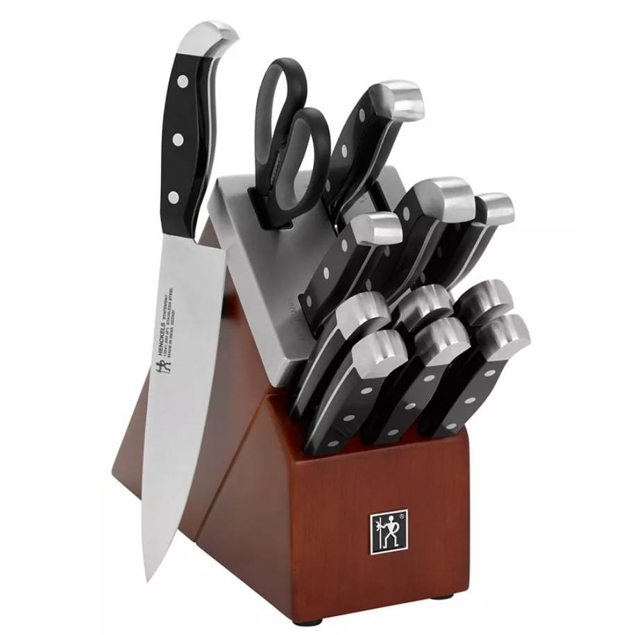 Knife block set featuring several knives with black handles, kitchen shears, and a wood block holder.