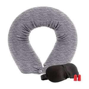 A gray, soft travel neck pillow is shaped like a horseshoe, accompanied by a black sleep mask and two red earplugs designed for comfort and noise reduction during travel.