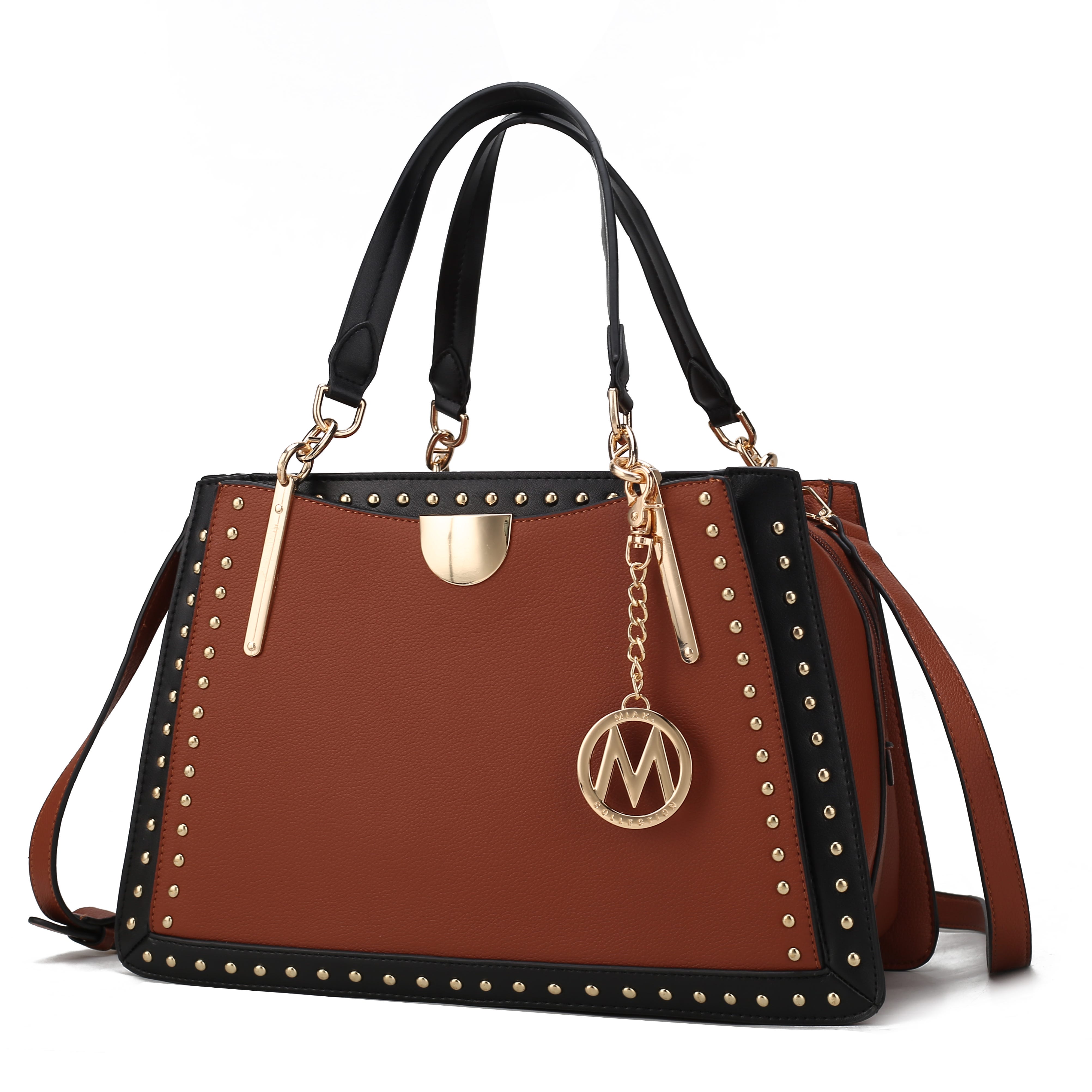 A brown and black handbag with gold accents and stud detailing, featuring a circular gold charm with an \“M\“ emblem.